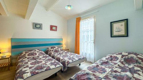 a bedroom with two beds and a window at Charmante location à proximité de la plage et des commerces in Rivedoux-Plage
