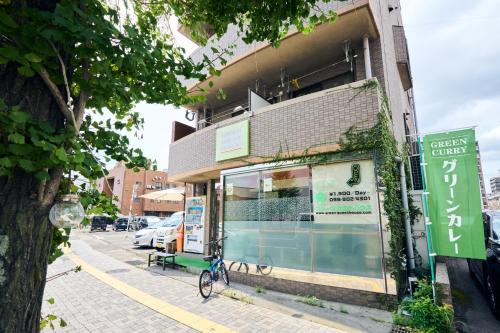 a bike parked outside of a store on a street at Green Guesthouse in Kagoshima