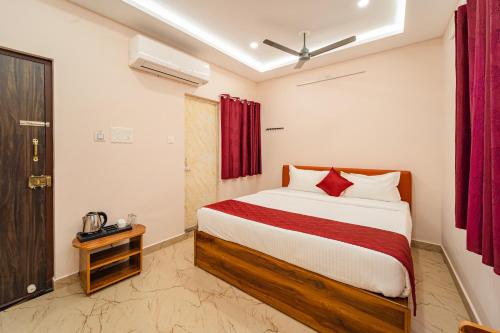 a bedroom with a large bed with red curtains at VSA Residency in Pūrnānkuppam