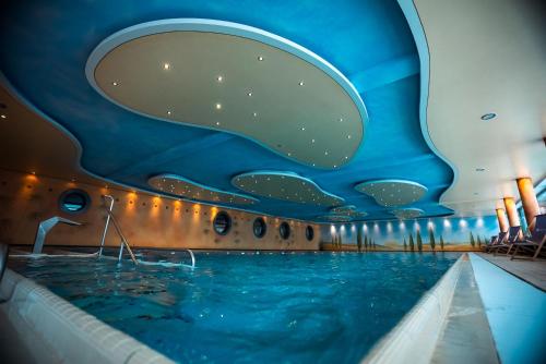 a swimming pool in a hotel with a blue ceiling at Hotel Hochsauerland 2010 in Willingen