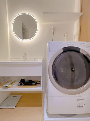 a washing machine in a room with a mirror at star house akihabara ueno tokyo in Tokyo