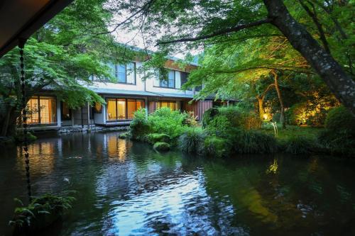 a house with a river in front of it at Oku Yugawara Tsubaki in Yugawara