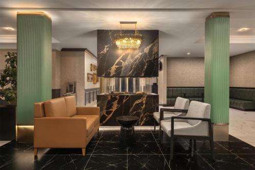 a lobby with two chairs and a chandelier at Hotel Vallea Bromont, Tapestry Collection by Hilton in Bromont
