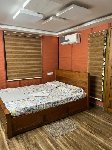 ein Schlafzimmer mit einem Bett in einem Zimmer in der Unterkunft Apricot Cottage in Kozhikode