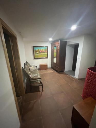 a living room with a chair and a painting on the wall at Casa do Canto in Macedo de Cavaleiros