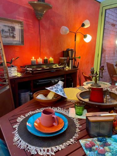 einen Tisch mit Teller mit Essen und Kerzen darauf in der Unterkunft Le Mas des Vignes parisian hacienda in Rueil-Malmaison