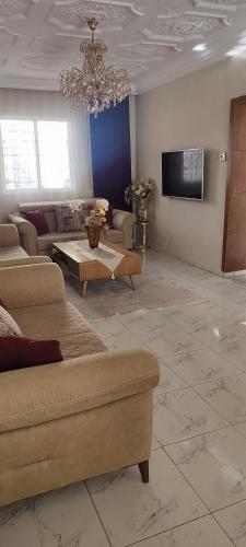 een woonkamer met een bank en een kroonluchter bij Myhouse in Ariana