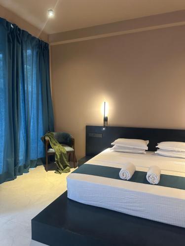 a bedroom with a large bed with blue curtains at Serenity Villa in Dickwella