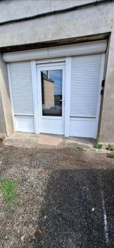 a garage with two doors on the side of a house at Joli studio indépendant in Noidans-le-Ferroux