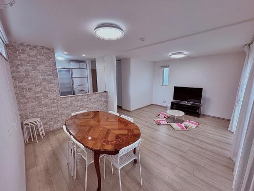 Una sala de estar con una mesa y un televisor. en Hotel Sakura 宇都宮, en Utsunomiya