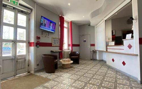 una hall con una sala d'attesa con una porta e una sedia di Au Royal Hotel a Carcassonne