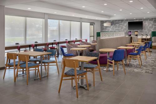 a restaurant with wooden tables and chairs and windows at Home2 Suites By Hilton Frankenmuth in Frankenmuth