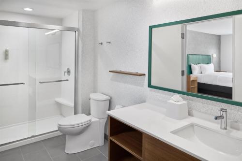 a bathroom with a toilet and a sink and a mirror at Home2 Suites By Hilton Frankenmuth in Frankenmuth