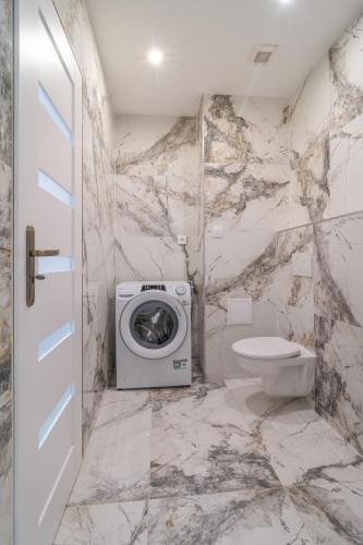 a bathroom with a washing machine and a toilet at Apartmán Alex, Nezábudka in Tatranska Strba