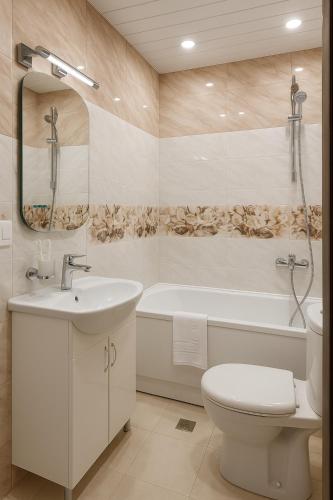 a bathroom with a sink and a toilet and a tub at Anga Yerevan Hotel in Yerevan