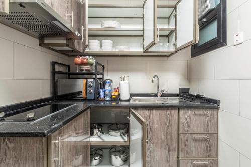 a kitchen with wooden cabinets and a sink at The Hideout, Khorfakkan in Khor Fakkan
