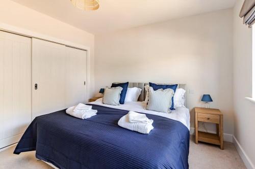 ein Schlafzimmer mit einem großen Bett mit Handtüchern darauf in der Unterkunft Spacious 4-BR House in Oxfordshire with Free Parking and Wi-Fi in Long Hanborough