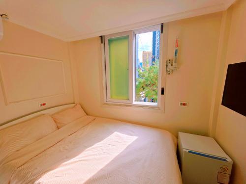 a small bedroom with a bed and a window at 가가하우스 을지로 in Seoul