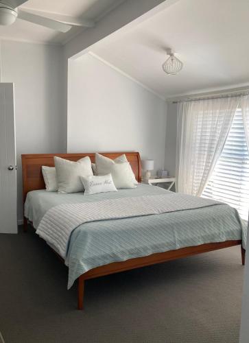 a bedroom with a large bed with white pillows at Riverview Cottage in Dunbogan