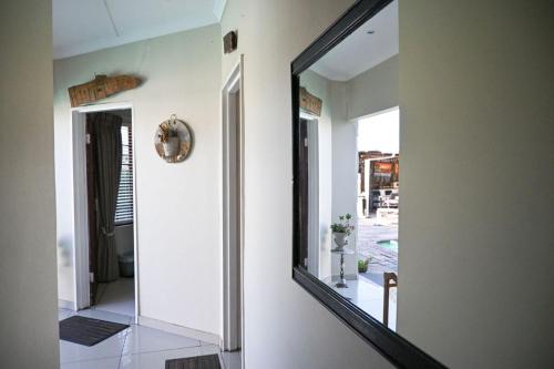 a mirror on the side of a room with a hallway at Matts Rest bnb & Selfcatering in Vosburg