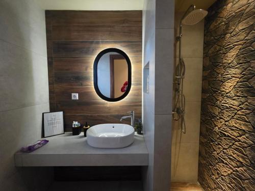 a bathroom with a sink and a mirror at Rastoni Suites Xylokastro 1 in Melission