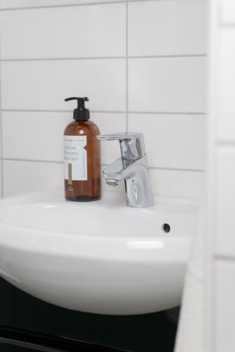 a soap bottle sitting on top of a bathroom sink at Large Central 2BR - Scandinavian Design - Balcony in Gothenburg