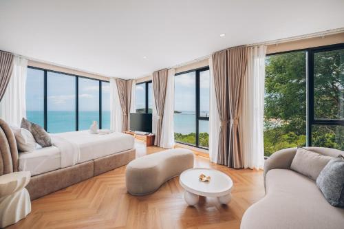 ein Wohnzimmer mit Bett und großen Fenstern in der Unterkunft Leva Boutique Hotel in Ko Samui