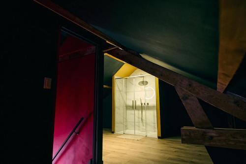a room with a red door and a bathroom at cinéma immersif et chambres à thème dans le centre in Saint-Omer