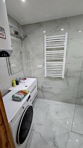 a white bathroom with a washing machine and a window at Hron River View Apartment 24h Self check -in Free Parking in Banská Bystrica