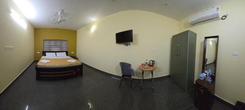 a bedroom with a bed and a table in a room at Nature's Frame Residency in Varkala