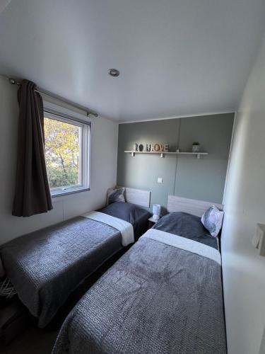 a bedroom with three beds and a window at U pino in Lumio