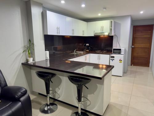 une cuisine avec un comptoir et des tabourets. dans l'établissement Cloud Apartments 2 Bedroom in Lautoka CBD, à Lautoka