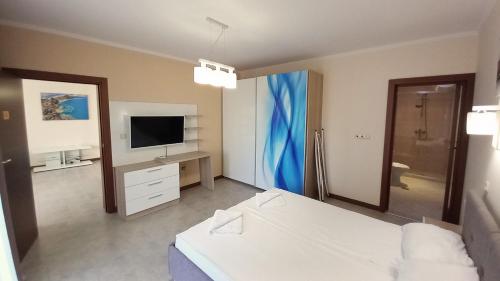 a hotel room with a bed and a television at 5-Star Beachfront Luxury Apartments in Sveti Vlas