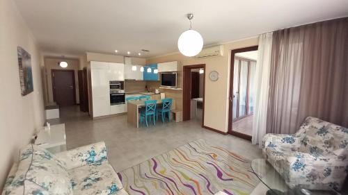 a living room with a couch and a kitchen at 5-Star Beachfront Luxury Apartments in Sveti Vlas