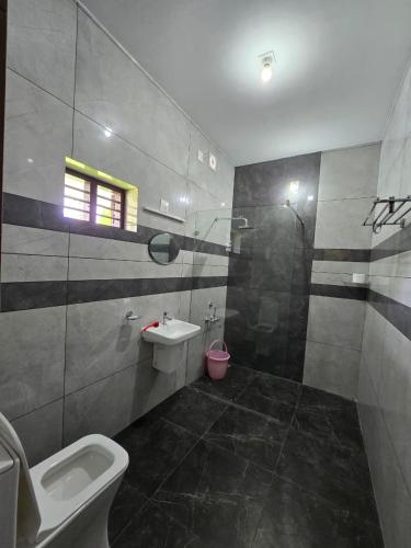 a bathroom with a toilet and a sink and a shower at Nature's Frame Residency in Varkala