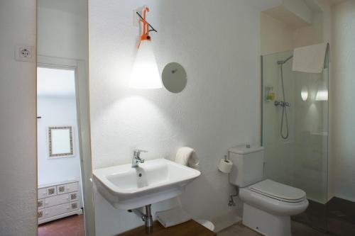 a bathroom with a sink and a toilet and a light at Hotel Cala Joncols in Roses