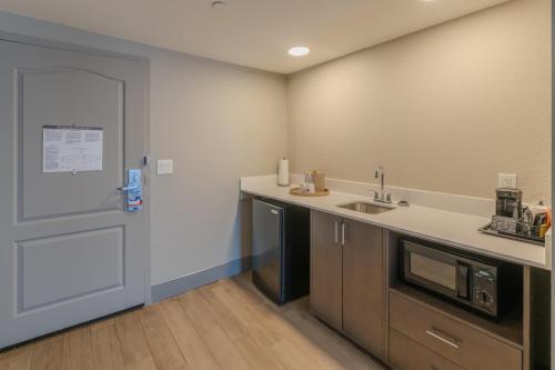 a kitchen with a sink and a microwave and a door at Hampton Inn & Suites-Florence Downtown in Florence