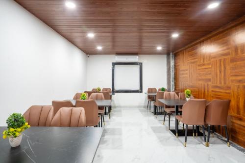 uma sala de conferências com mesas e cadeiras e uma tela em Sunrise Hotel Shamshabad em Hyderabad