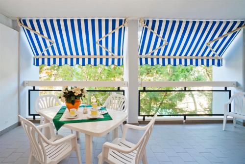 une salle à manger avec une table et des chaises et une fenêtre dans l'établissement Auriga del Sole, à Bibione