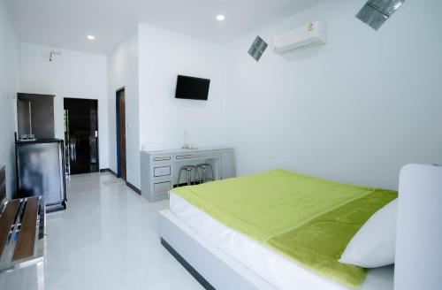 a white bedroom with a bed and a television at Thongkon Hotel in Surin