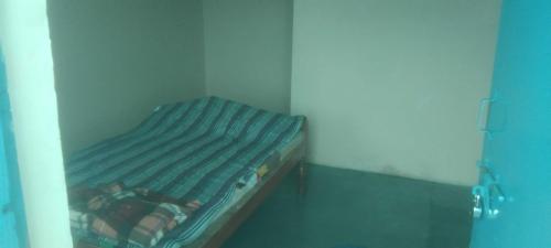 a small bed in a room with a blue bed frame at Hotel O Chandrapur Gadchandur formerly Hotel Relax in Chāndur