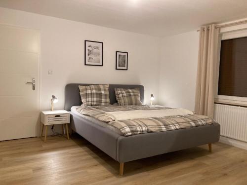 a bedroom with a bed with a nightstand and a window at Ferienwohnung Dorfliebe Minden by Engelmann in Minden