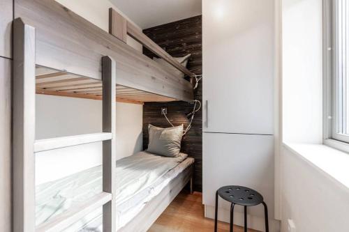 Ce lit superposé se trouve dans une petite chambre avec un tabouret. dans l'établissement Lindvallen Ski Resort - Sauna - 6 Guests, à Sälen
