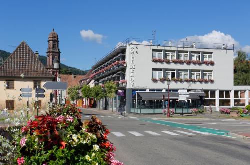 a street in a town with a white building at The Originals City Hotel de l Ange Guebwiller in Guebwiller