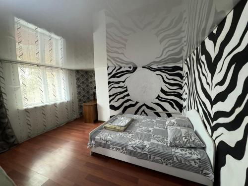 a bedroom with a bed with a zebra print wall at Уютный коттедж с мангалом и казаном - 8 минут до пляжа in Borovoye