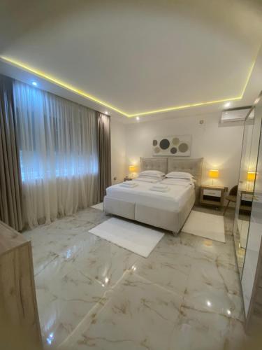 a large white bedroom with a bed and a mirror at Beige Harmony in Smederevo