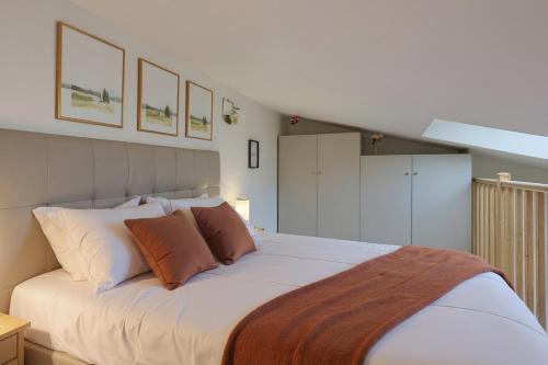 a bedroom with a large white bed with orange pillows at Le Petit Chalet in Vitry-sur-Seine