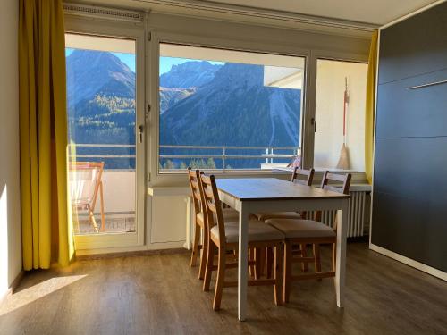 ein Esszimmer mit Tisch und Stühlen und einem großen Fenster in der Unterkunft Fortuna 8 by Arosa Holiday in Arosa