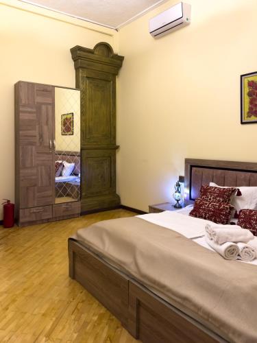 a bedroom with a large bed and a mirror at Suvenir Hotel in Baku