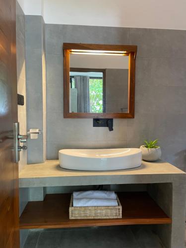 a bathroom with a sink and a mirror at Bloom Beach Villa in Batigama